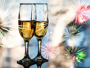 champagne glasses against  fireworks
