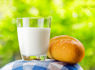 Fresh milk and bread on nature background