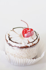 Cupcake with whipped cream and cherry isolated on whit