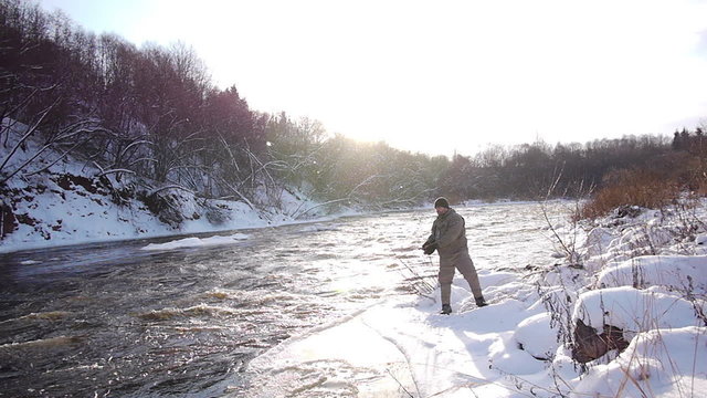 Man fishing trout in forest river