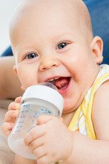 Pretty baby boy drinking water from bottle
