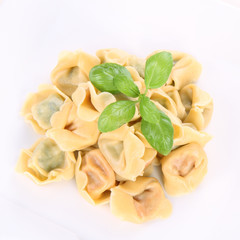 Tortellini on a plate decorated with fresh basil