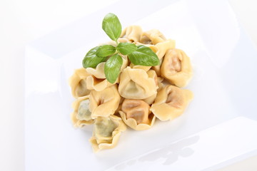 Tortellini on a plate decorated with fresh basil