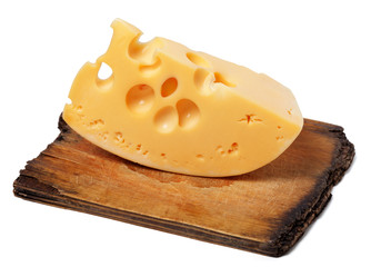 Piece of cheese on old wooden kitchen board