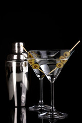 Martini glass with olives and shaker isolated on black