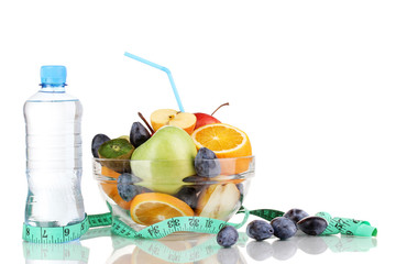 Glass bowl with fruit for diet, measuring tape and water bottle