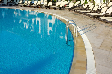 Obraz na płótnie Canvas Basen hotelowy ze słonecznymi refleksami.