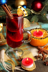 Fragrant mulled wine in glass with spices and oranges around