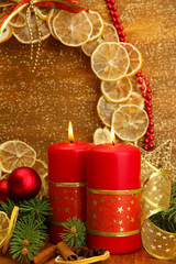Fototapeta na wymiar Two candles and christmas decorations, on golden background