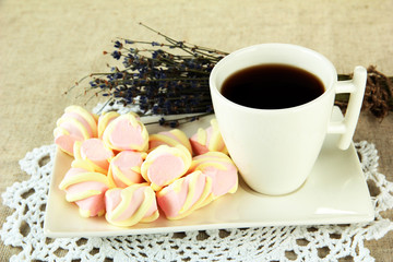 Marshmallows on plate on light background