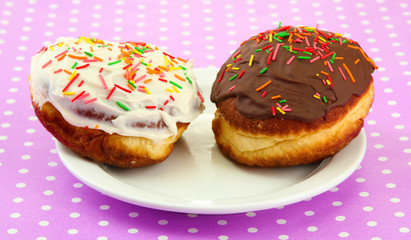 Tasty donuts on color plate on color background