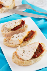 bread with chicken and dry tomato on the plate