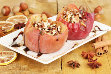 Baked apples on plate on wooden table