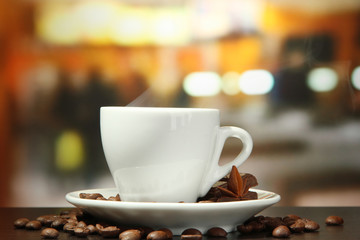 cup of coffee with beans on table in cafe