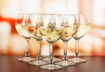 White wine in glass on room background