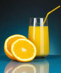 Delicious orange juice in glass and oranges next to it