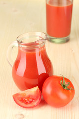 Full jug of tomato juice, on wooden background