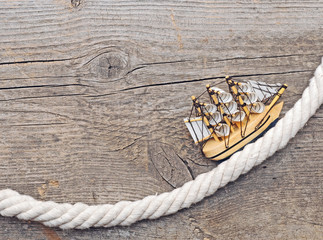 rope and model classic boat on wood background