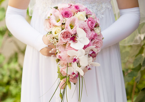 wedding bouquet of roses in the hands of the bride