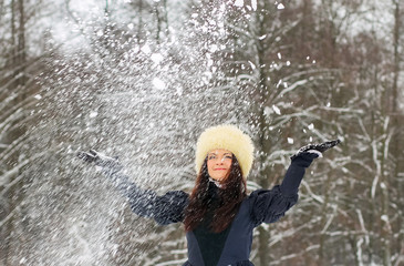 Fototapeta na wymiar young woman playing with snow