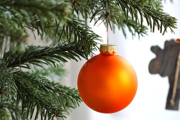 Orange Christmas bauble on branch