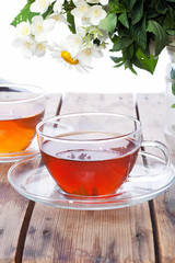 Cup with green tea and fresh herbs