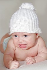 Portrait of the baby in a white knitted hat (3 months)