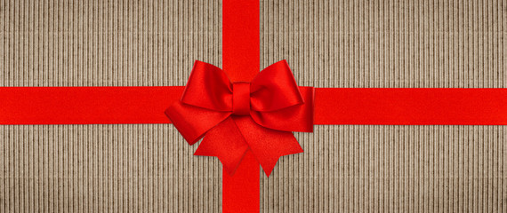 red ribbon bow on recycled cardboard paper background