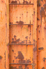 steps of old orange and rusty container on vertical image
