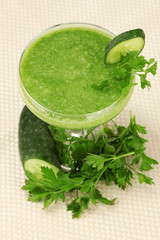 Green vegetable juice in coctail glass on light background