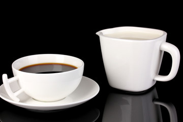 A cup of strong coffee and sweet cream isolated on black