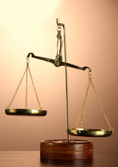 Gold scales of justice on brown background