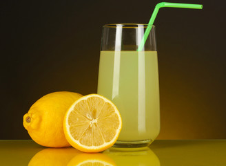Delicious lemon juice in glass and lemons next to it