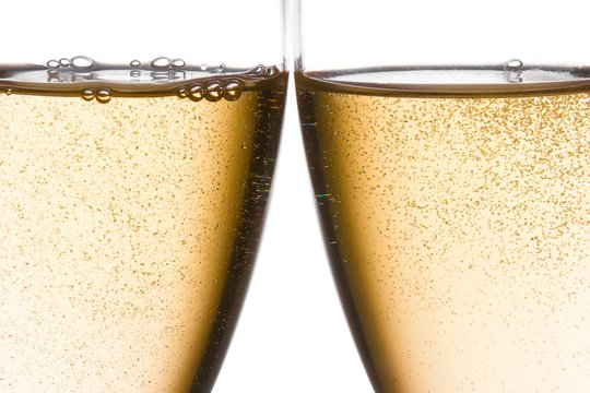 detail of cheers with two champagne glasses with gold bubbles