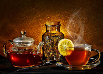 glass teapot and cup on golden background