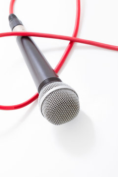 Microphone with red cable on white background