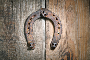 The old horseshoe hanging on wooden wall
