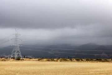 Electricity pylon in a field of straw