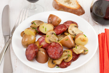 salad chorizo with potato and fried champignons on the plate
