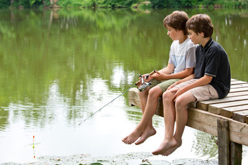Zwei jungendliche Freunde angeln am idyllischen Teich