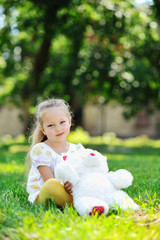 Sweet little girl with a toy in the park