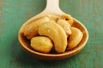 Salted cashews in wooden spoon