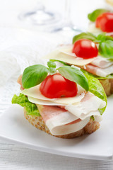 Sandwich with prosciutto, parmesan cheese and tomato
