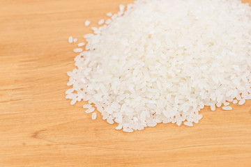 Pile of raw rice on wooden table