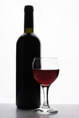Bottle of red wine with glass