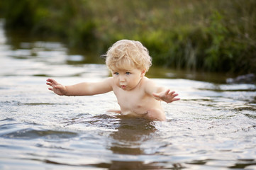 Fototapeta premium little funny boy playing in water
