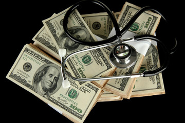 Healthcare cost concept: stethoscope and dollars isolated