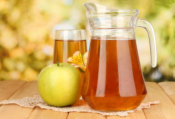 Full glass and jug of apple juice and apple