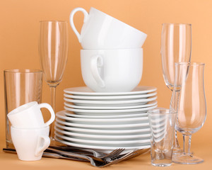 Clean white dishes on beige background