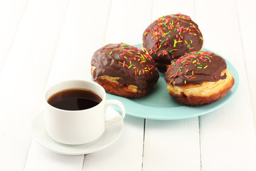 Tasty donuts on color plate on light wooden background